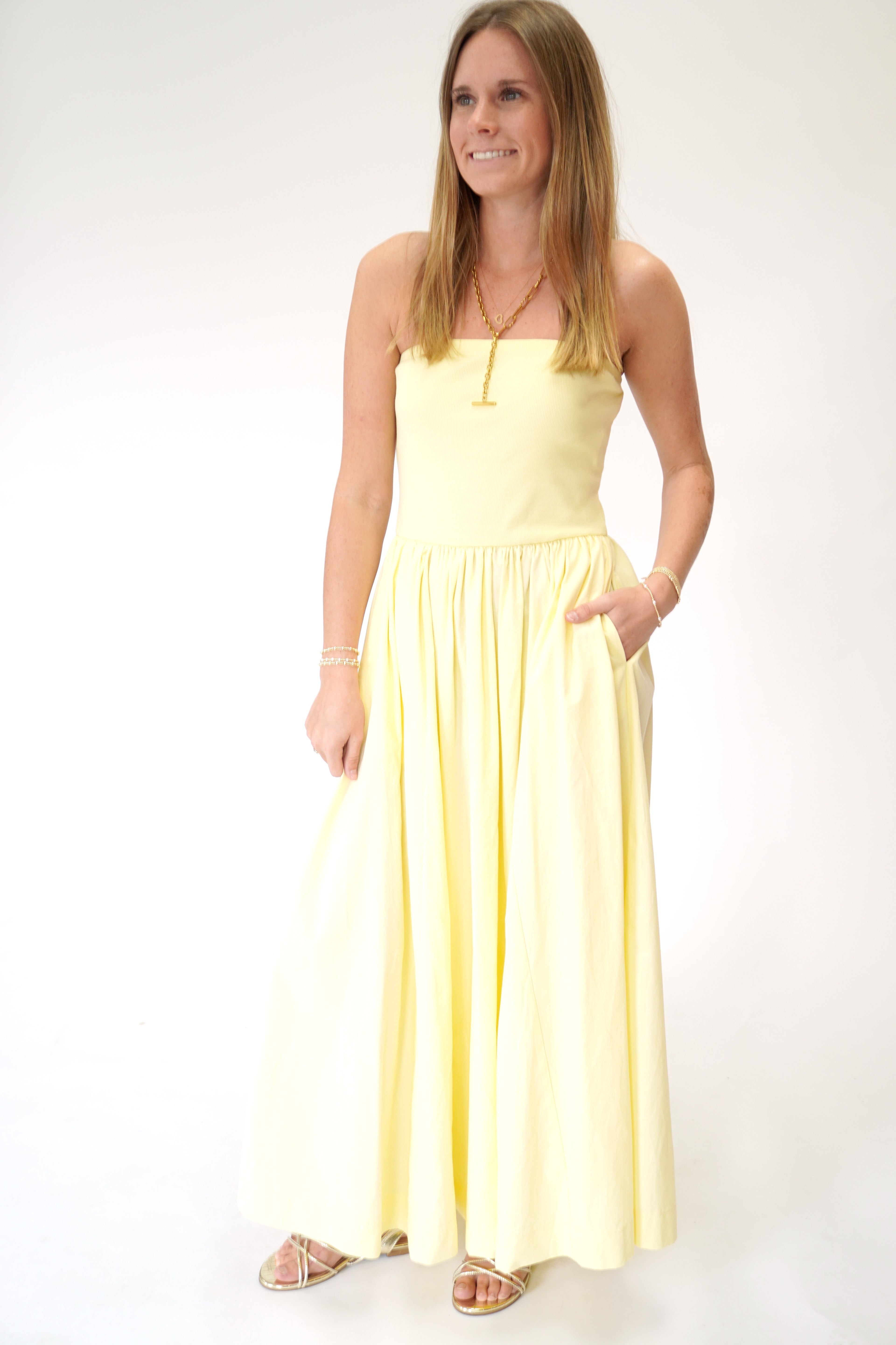 Soft pastel yellow strapless maxi dress with gathered waist and airy skirt.