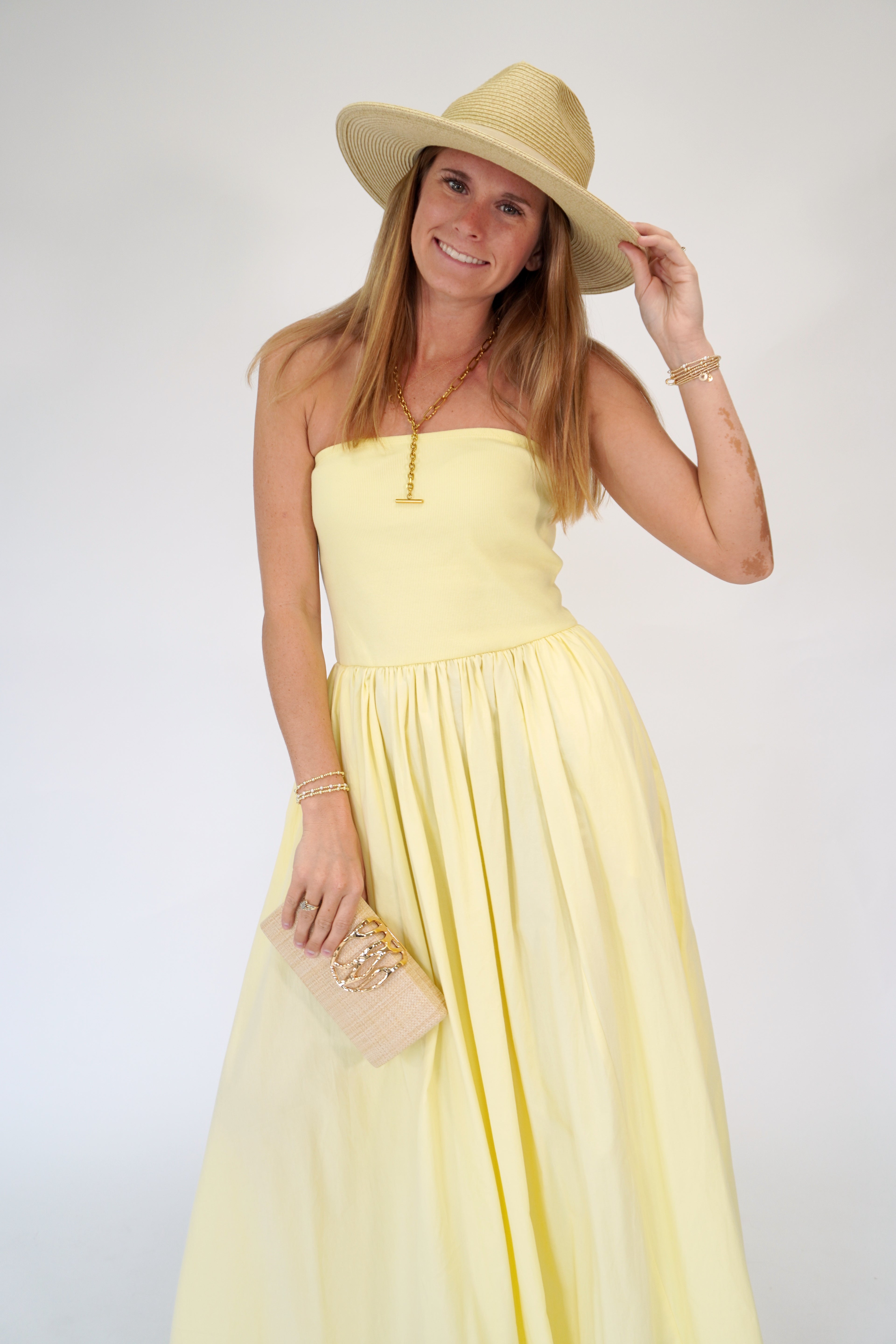 Light yellow strapless maxi dress with fitted bodice and breezy full skirt.