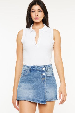 Woman wearing a white sleeveless top and denim skirt on a white background