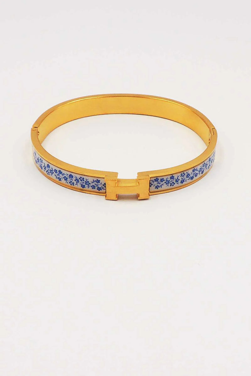 Gold belt with blue floral pattern on a white background
