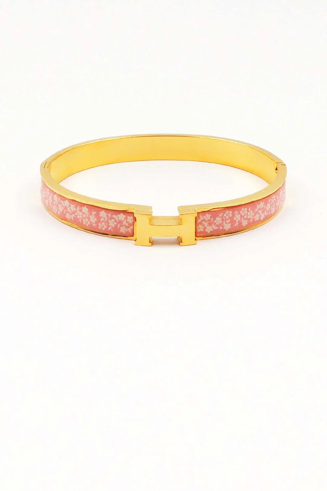 Pink bracelet with gold clasp on a white background
