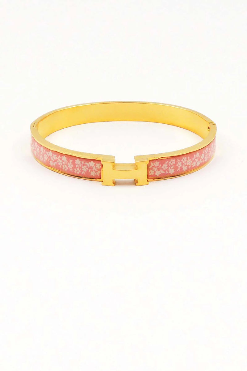 Pink bracelet with gold clasp on a white background