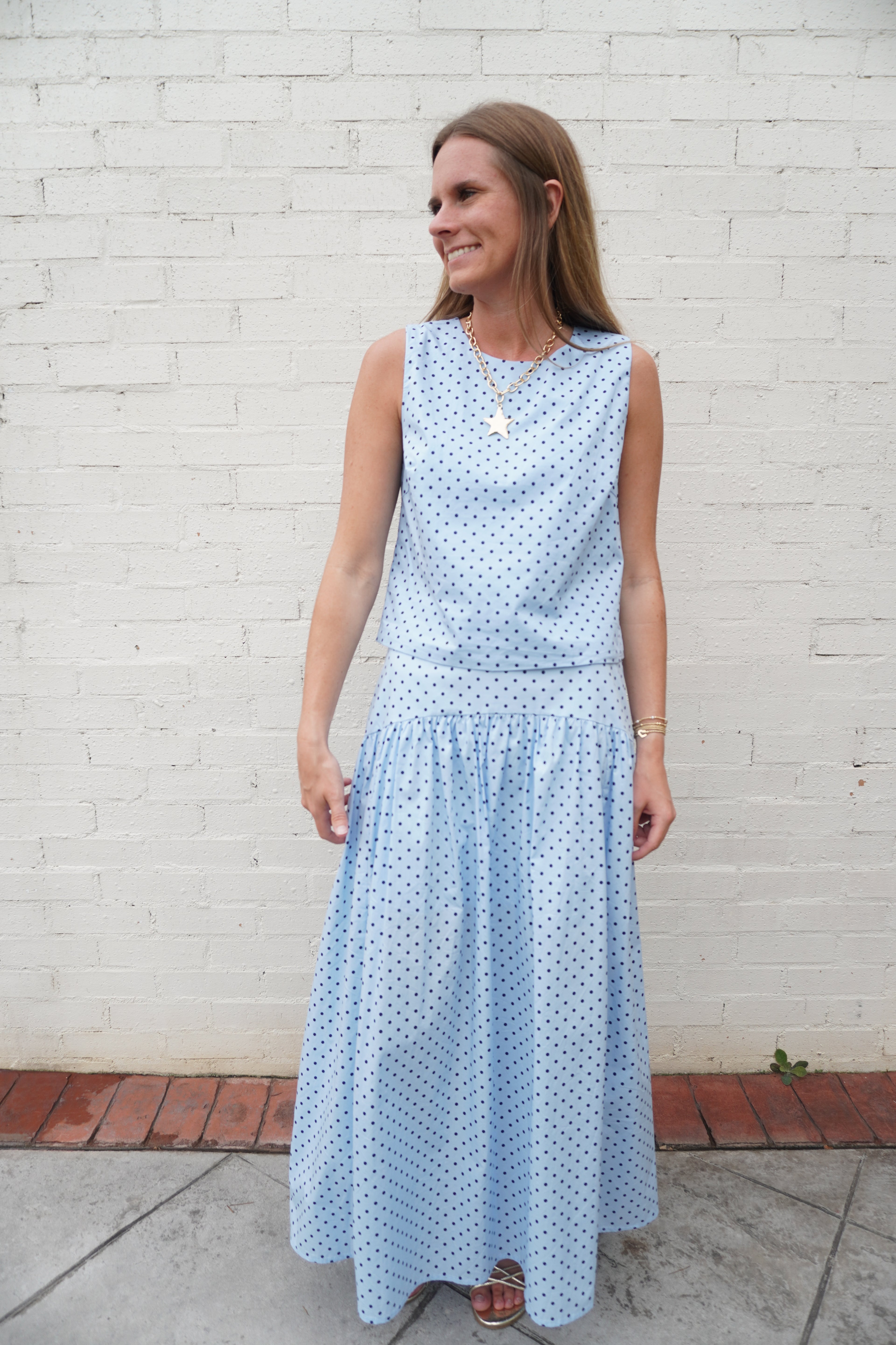 Light blue polka dot sleeveless blouse featuring a relaxed straight fit silhouette and timeless summer styling.