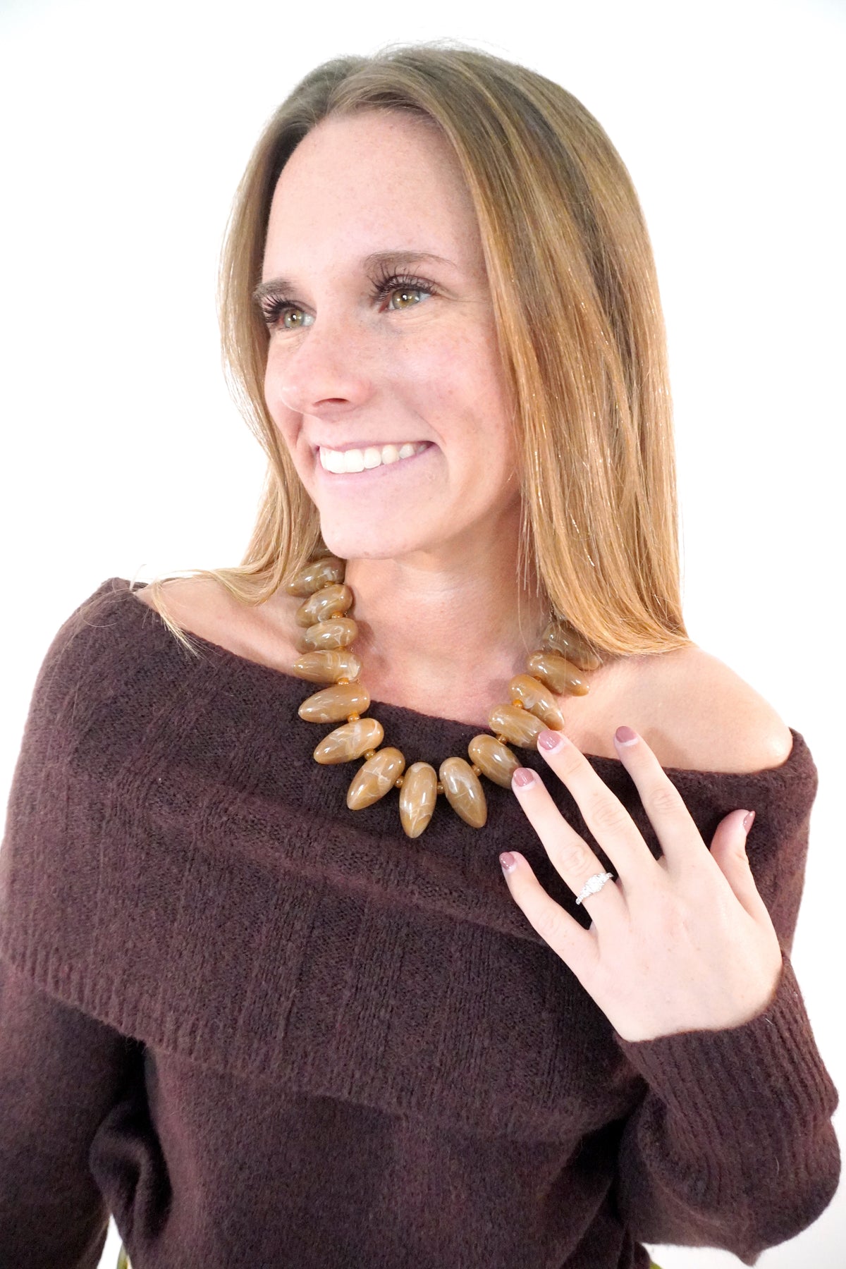 Large caramel marbled beaded collar necklace worn with a chocolate brown off-shoulder sweater