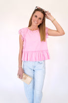 Pink peplum top with lace sleeves and relaxed fit styled with light wash jeans