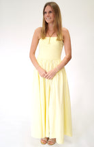 Bright butter yellow strapless maxi dress with feminine flowy design perfect for warm weather.