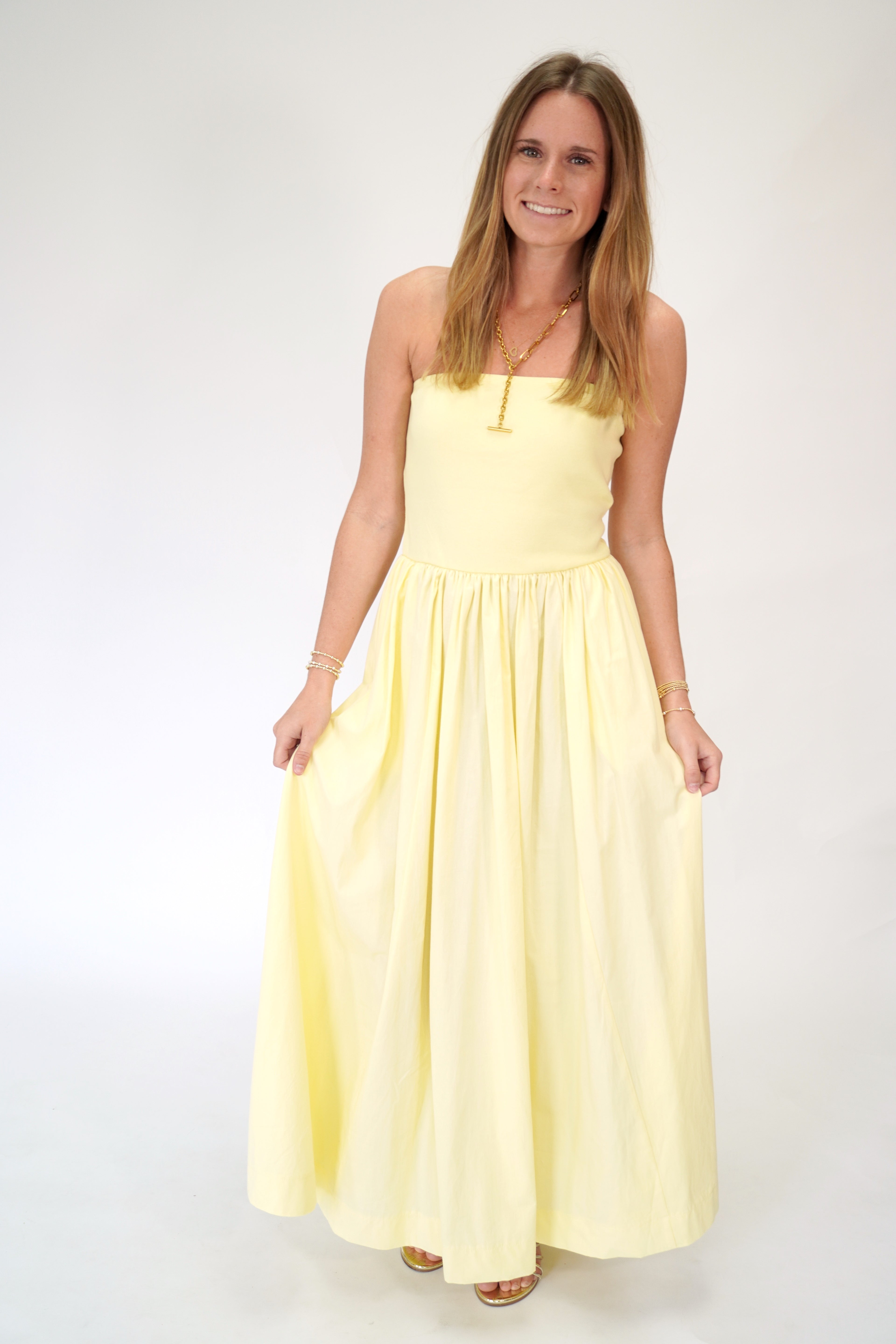Butter yellow strapless maxi dress with flowy skirt and soft feminine silhouette.