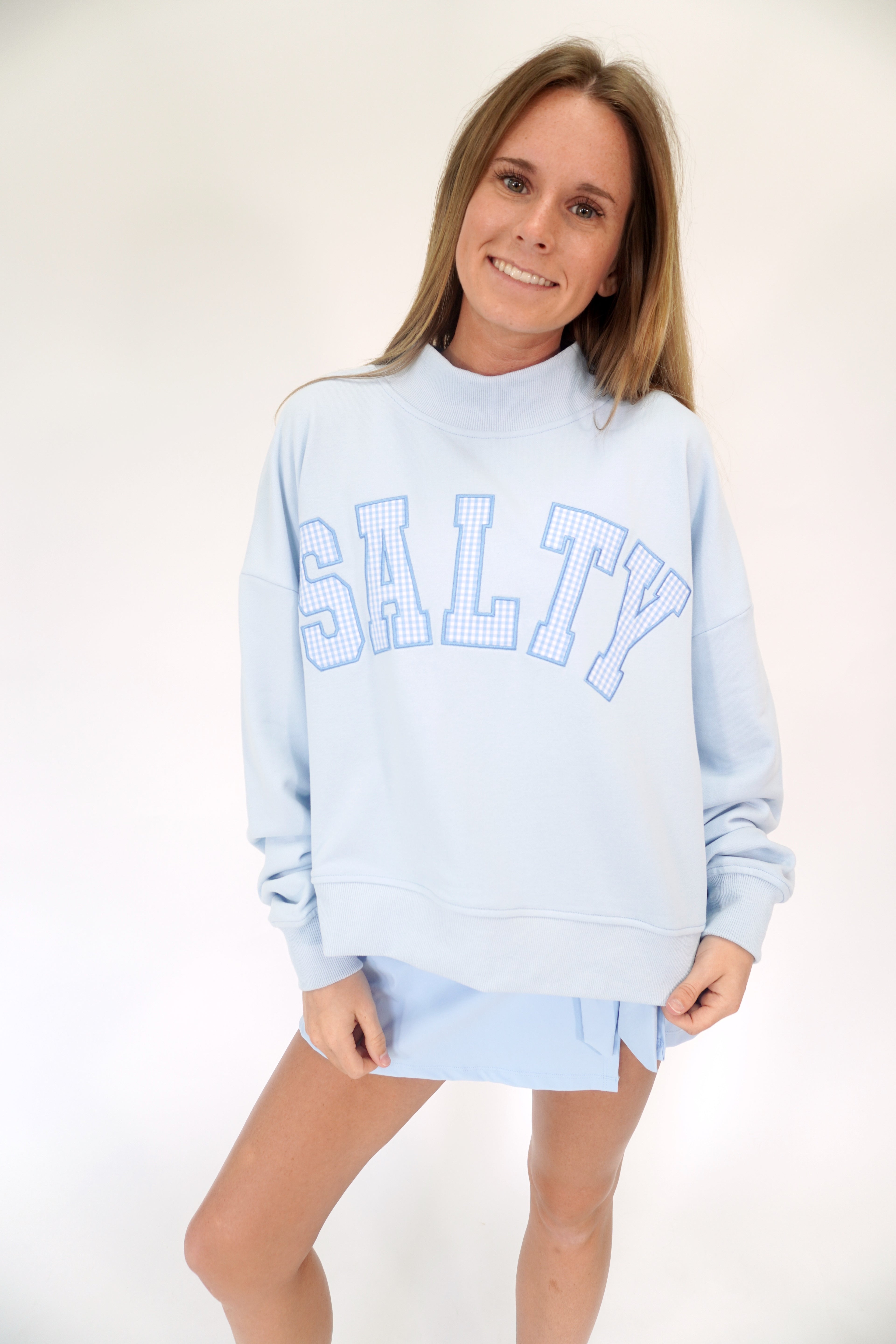 Light blue mock neck pullover sweatshirt with SALTY graphic and laid-back coastal vibe.