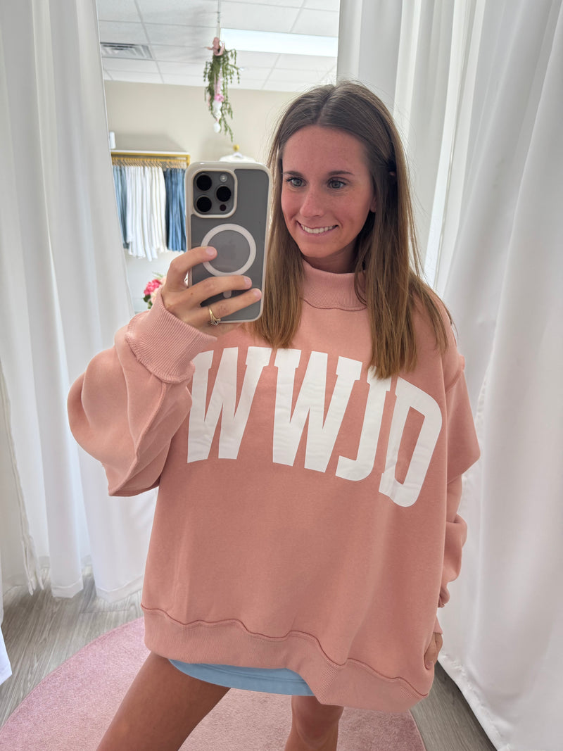 Woman wearing blush pink WWJD mock neck sweatshirt with oversized fit
