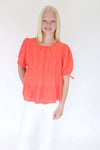 Sunset Breeze Tiered Babydoll Top - Coral Orange one hand on pocket