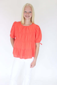 Sunset Breeze Tiered Babydoll Top - Coral Orange one hand on pocket