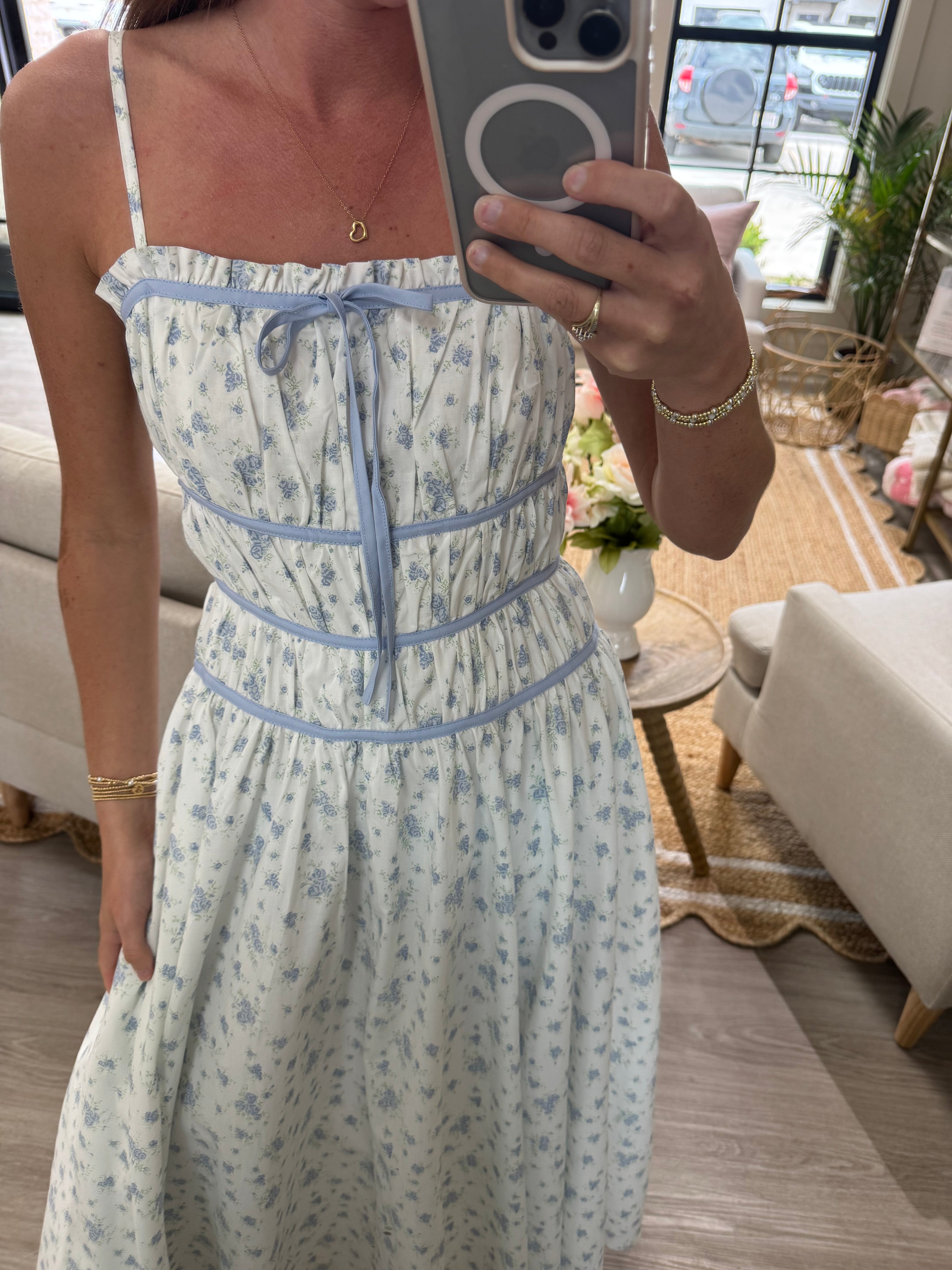 Light blue floral print midi dress with fitted bodice, tie front detail, and soft romantic style.