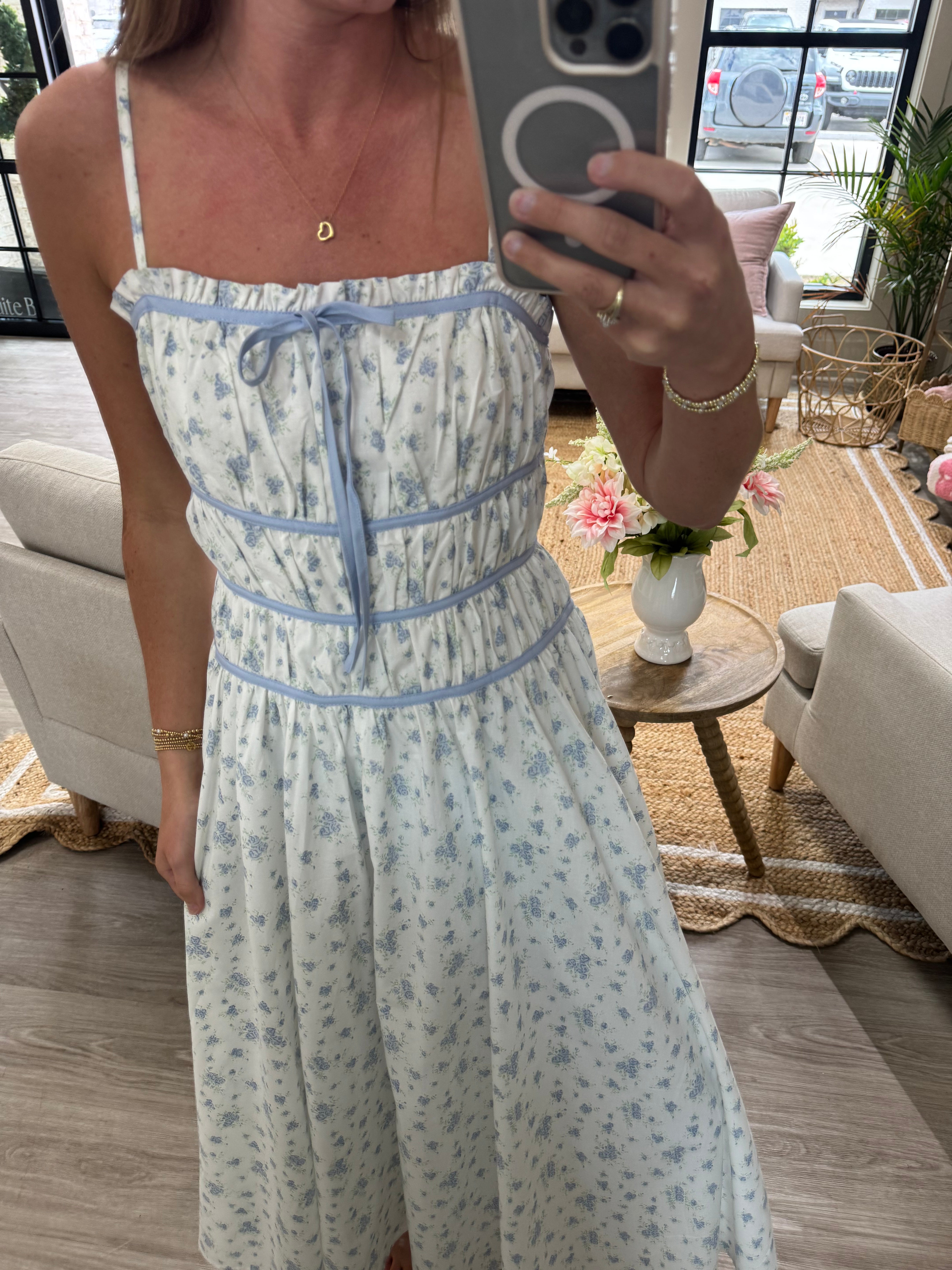 White floral sundress with blue print, spaghetti straps, and flattering gathered waist.