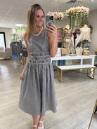 Woman wearing a floral wrap dress with tan sandals, styled outfit from Anderson Ave Boutique