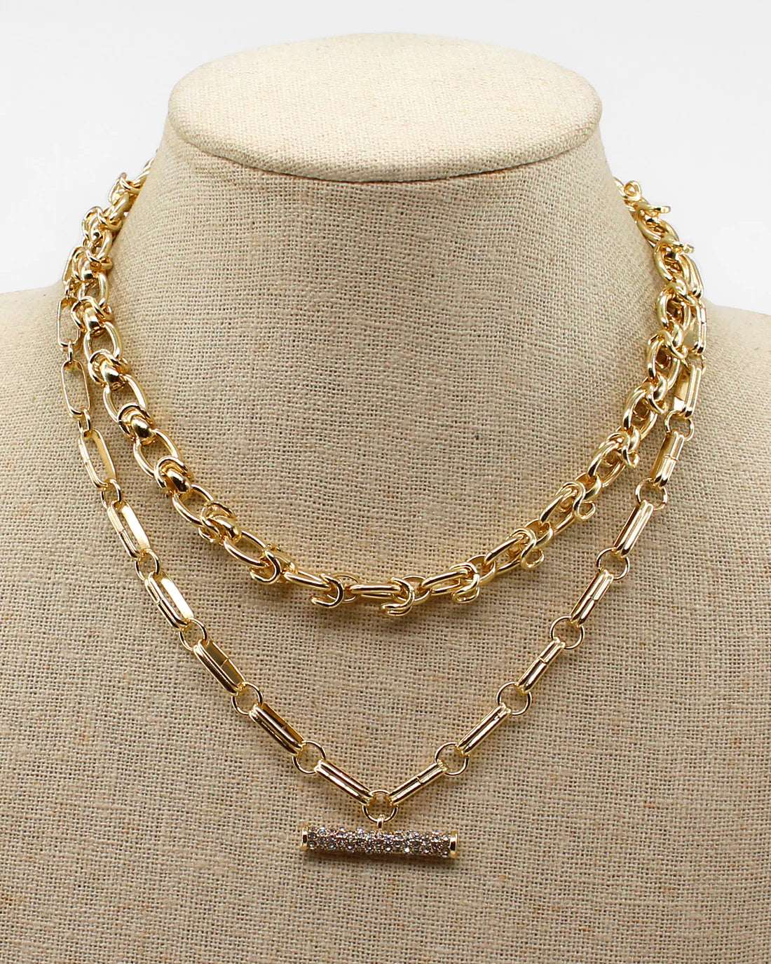 Gold chain necklace on a beige mannequin bust