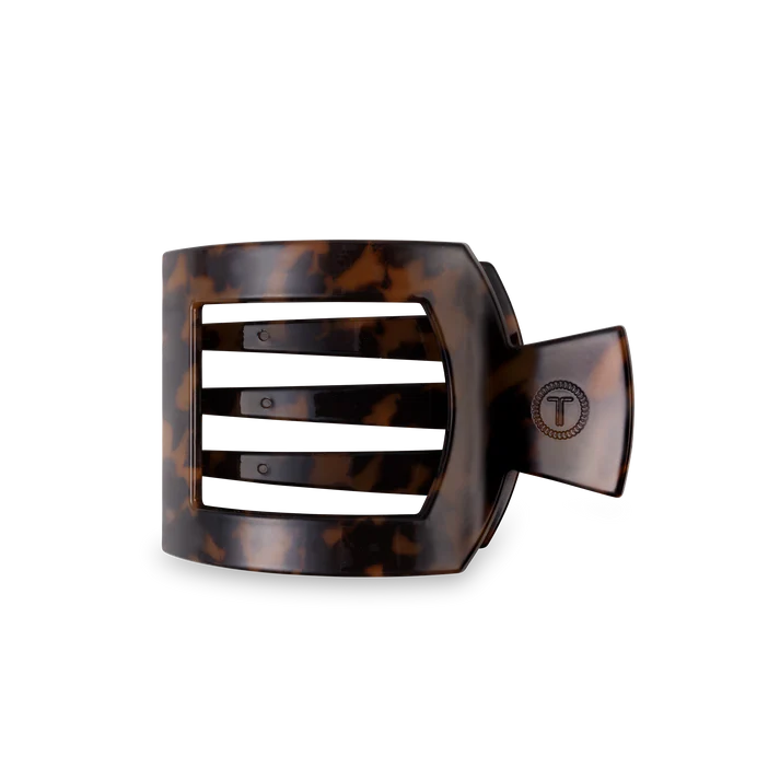Tortoiseshell hair clip with a brand logo on a white background
