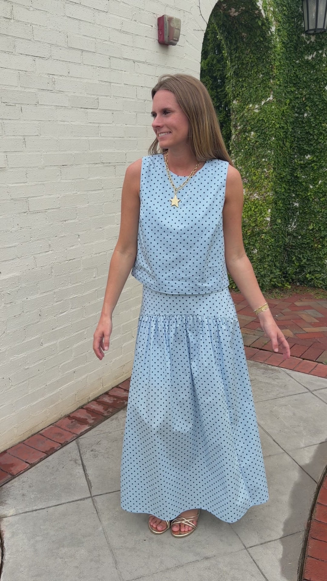 Light blue sleeveless boutique top with navy polka dots styled for a polished summer look.