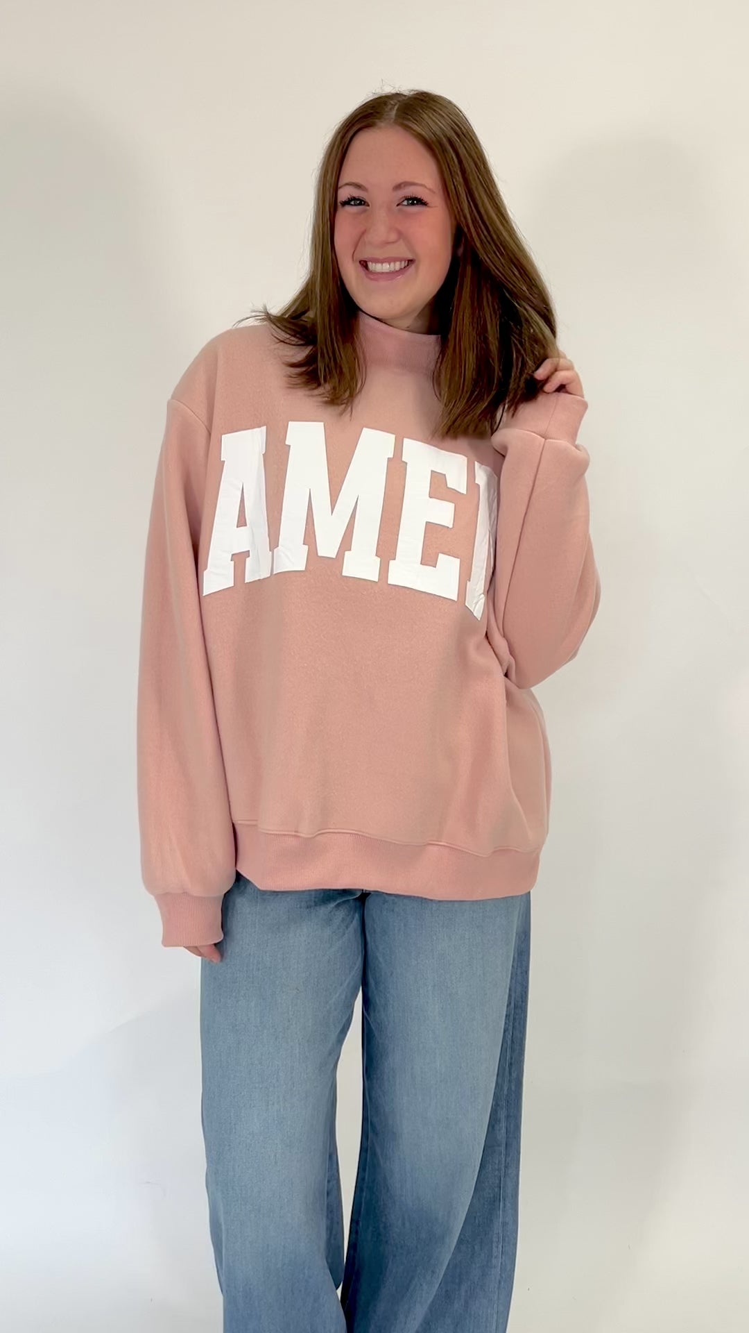 Faith-based pink sweatshirt with oversized fit and bold WWJD graphic